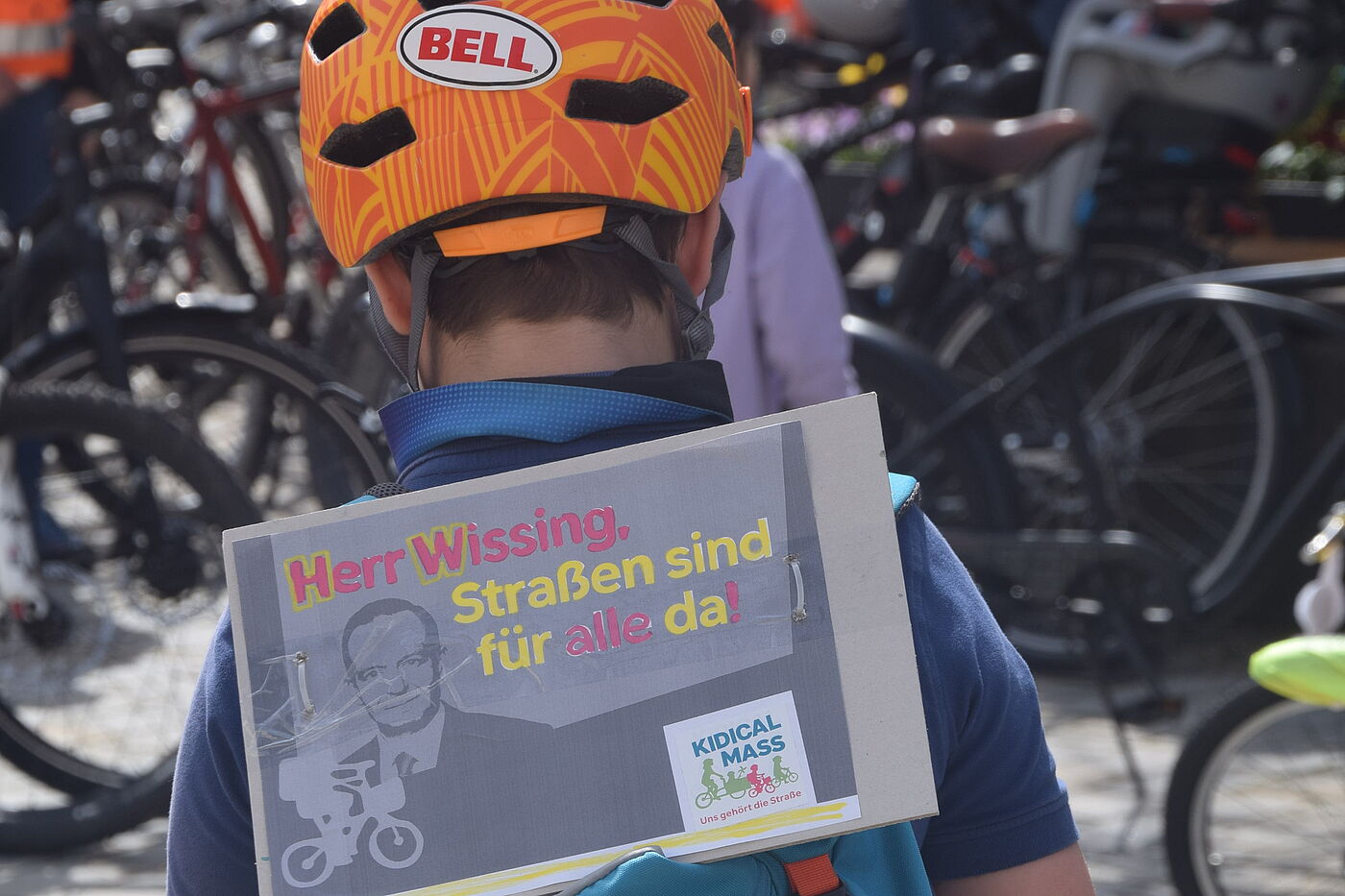 Kind mit Fahrradhelm, Rucksack und Demoplakat
