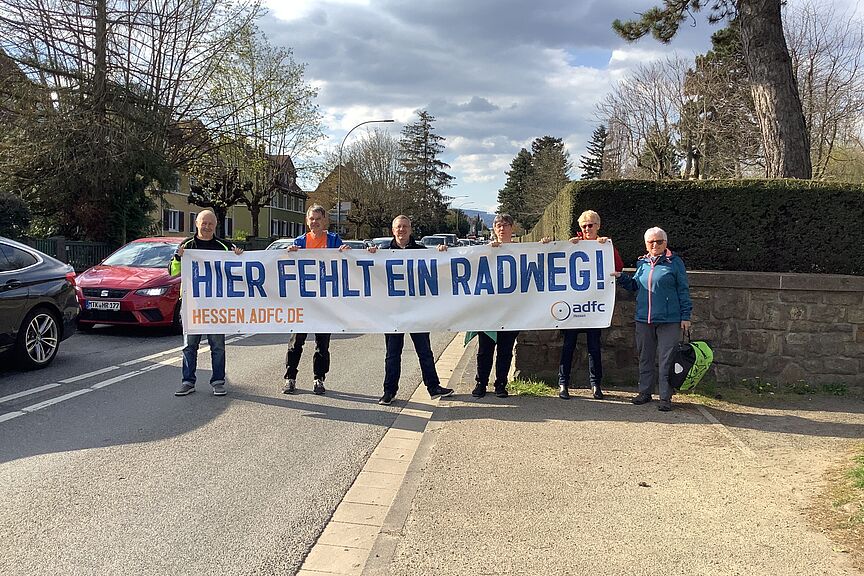 Frankfurter Landstraße: Radweg fehlt Personengruppe hält Banner hoch "Hier fehlt ein RAdweg"